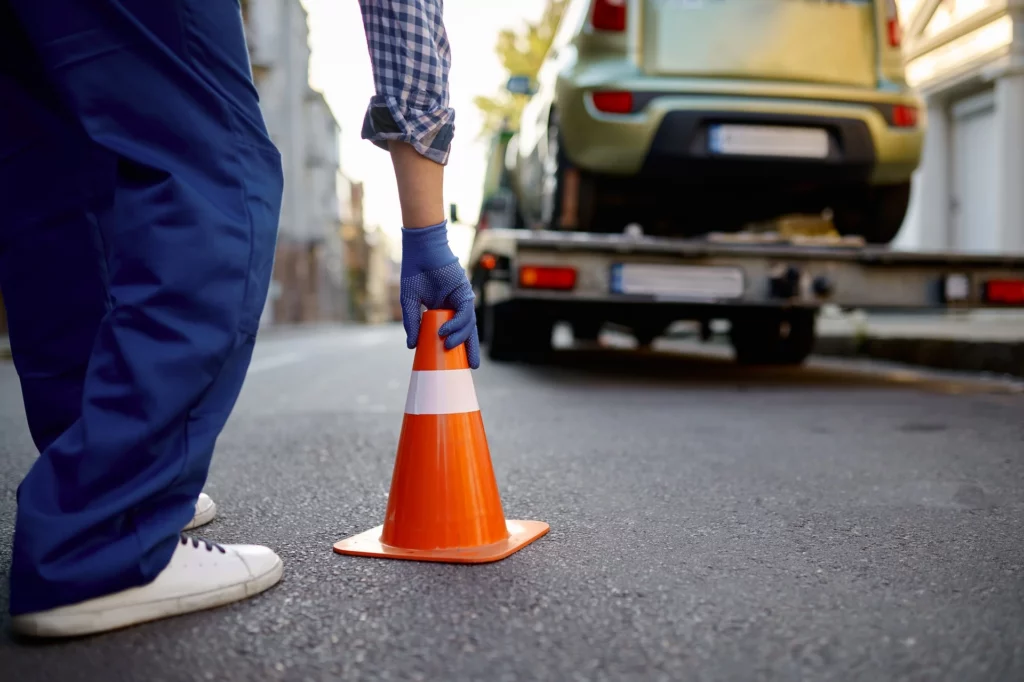 Wegenwerker plaatst een verkeerskegel langs de weg